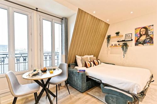 une chambre d'hôtel avec un lit, une table, une table et des chaises dans l'établissement Studio élégant à Neuilly entre Paris et La Défense, à Neuilly-sur-Seine