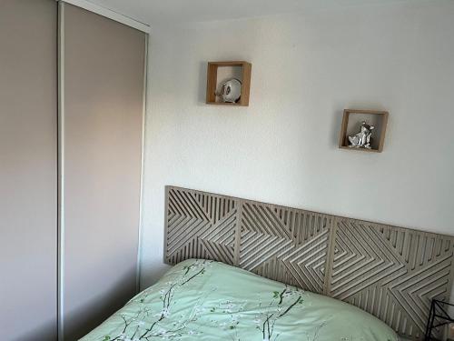 - une chambre avec un lit doté d'un miroir et d'une tête de lit dans l'établissement appartement 2 étoile à moins de 100m de la plage vu sur Le Canigó, à Saint Cyprien Plage