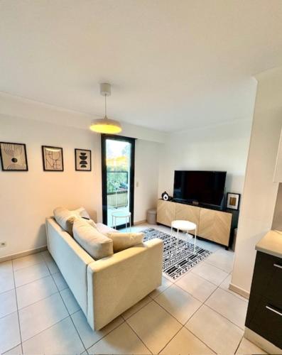 un salon avec un canapé et une télévision dans l'établissement T2 apartment with terrace in Fréjus, à Fréjus