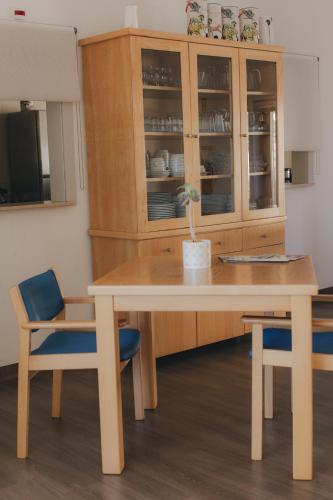 a table and two chairs and a wooden cabinet at Centro Rewilding in Vale de Madeira
