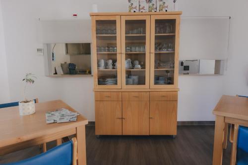 a wooden cabinet with dishes in it in a room at Centro Rewilding in Vale de Madeira