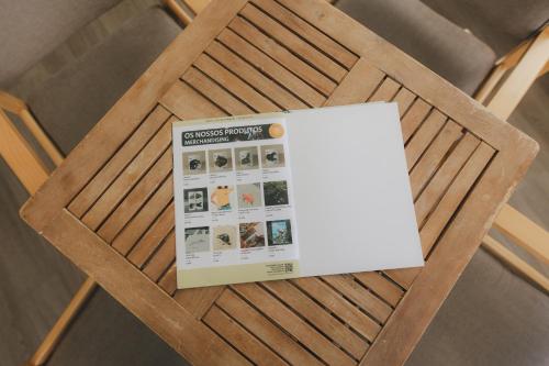 a magazine sitting on top of a wooden chair at Centro Rewilding in Vale de Madeira