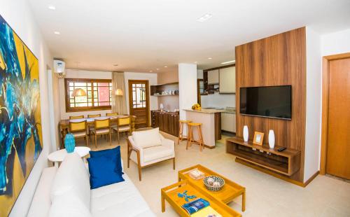 - un salon avec un canapé blanc et une télévision dans l'établissement Pé na areia - Furstberger, à Praia do Forte