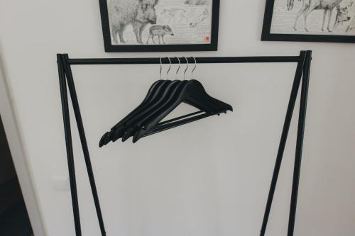 a shelf with black clothes hanging on a wall at Centro Rewilding in Vale de Madeira