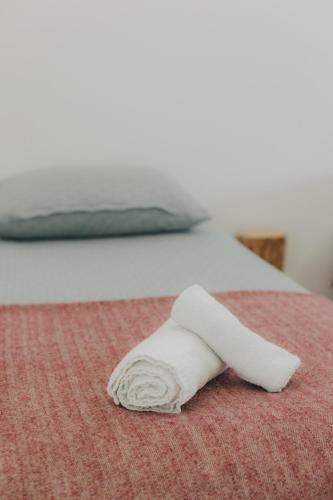 a white towel laying on a bed at Centro Rewilding in Vale de Madeira