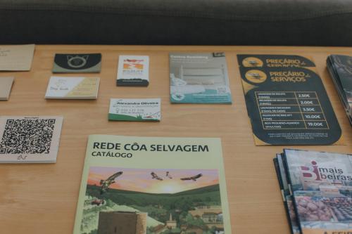 a table with signs and other items on it at Centro Rewilding in Vale de Madeira