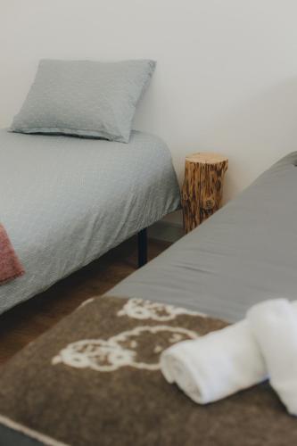 a bedroom with a bed and a rug with a dog on it at Centro Rewilding in Vale de Madeira