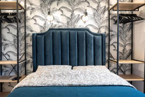 - un lit avec une tête de lit bleue dans une chambre dans l'établissement The Design Shelter - Duke Housing, à Vitry-sur-Seine