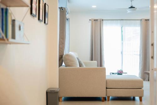 a living room with a chair and a window at Sunny's Cozy Home in Bophut 