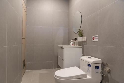 a bathroom with a white toilet and a mirror at Sunny's Cozy Home in Bophut 