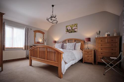 una camera con letto in legno e cassettiera di Humble Bee Cottage a Folkton