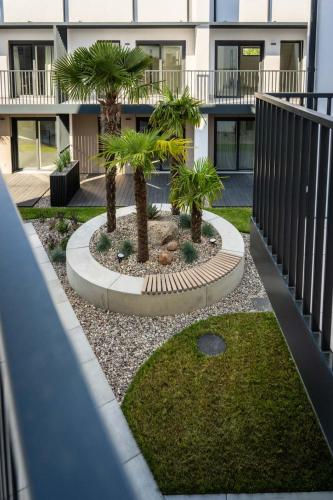 a courtyard with palm trees in front of a building at Apartamenty Wyspa Jastarnia Morski in Jastarnia