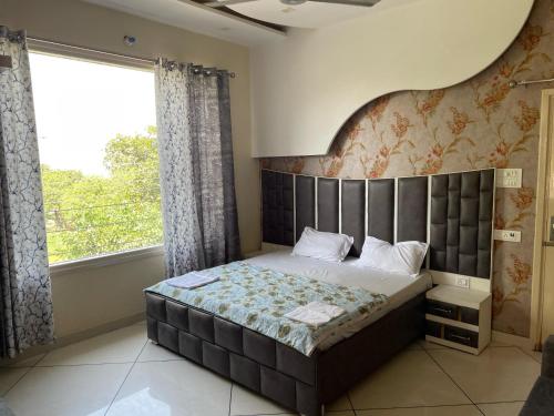 a bedroom with a large bed and a large window at Pine Wood Villa in Mānānwāla