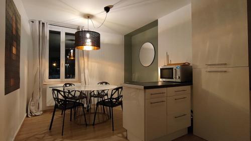 een keuken met een tafel met stoelen en een magnetron bij Mona Lisa in Sallaumines