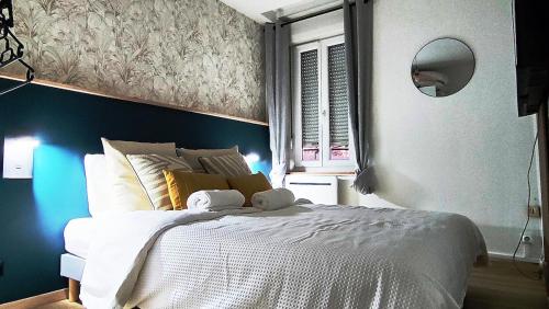 een slaapkamer met een groot wit bed en een blauwe muur bij Mona Lisa in Sallaumines