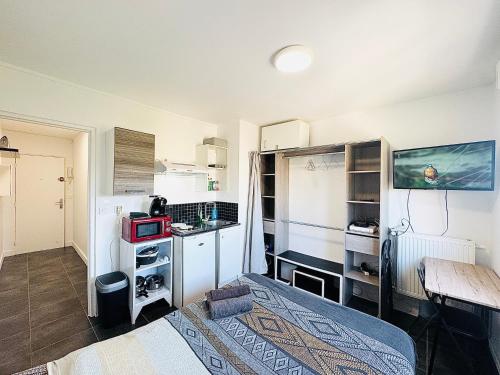 Cette petite chambre comprend un lit et un bureau. dans l'établissement STUDIO A 300 METRES DE LA GARE et 25 MINUTES DE PARIS EN TRAIN, à Melun
