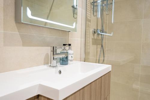 a bathroom with a white sink and a shower at St Kitts Apartment in Filey