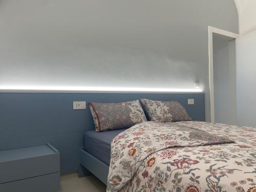 a bedroom with a bed with a blue wall at La casa de lu Barone in San Demetrio neʼ Vestini
