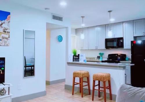 a kitchen with a counter and stools in a room at Luxury Midtown Suite in Houston near TMC and NRG in Houston