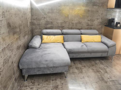a gray couch with two yellow pillows in a room at Luna Apartments B in Suceava