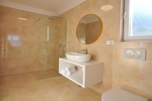 a bathroom with a toilet and a sink and a mirror at Villa Iva in Omiš