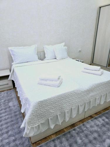 a large white bed with two towels on it at Golden house deluxe 2 in Bukhara