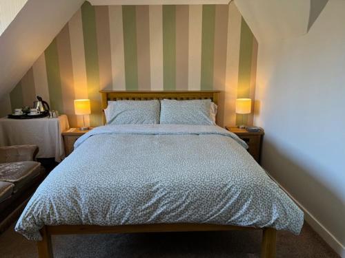 a bedroom with a bed with two lamps on two tables at Stobahn Guest House in Fort William