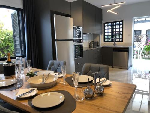 a dining room table with chairs and a kitchen at Luxurious 3-Bed Villa, Modern Decor, Communal Pool in Paphos