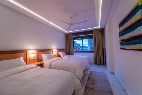 Una habitación de hotel con dos camas y una ventana. en Dar bensaid, en Chefchaouen