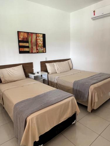 a hotel room with two beds in a room at Vila Lençóis Residence in Santo Amaro