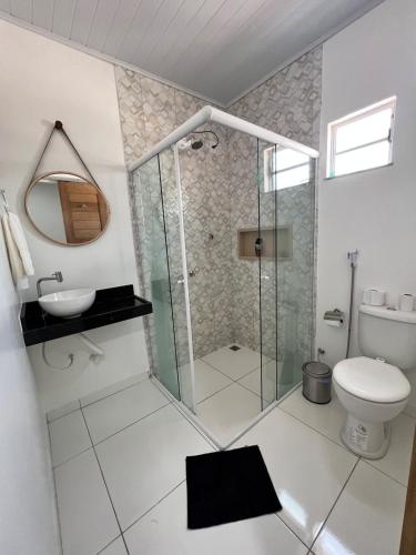 a bathroom with a shower and a toilet at Vila Lençóis Residence in Santo Amaro