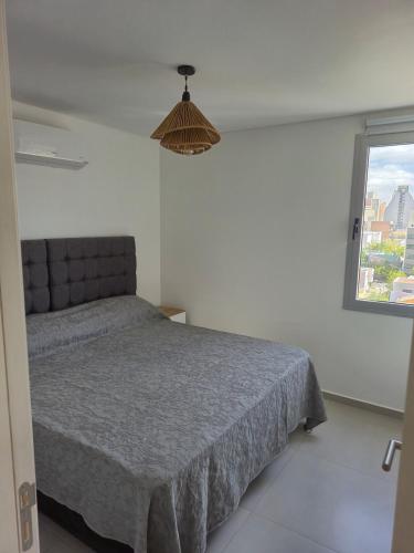 a bedroom with a bed and a window at Beautiful brand new apartment in Neuquén
