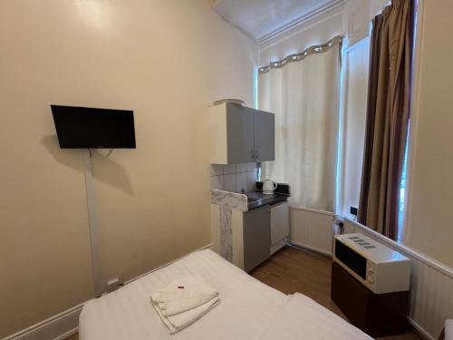 a small room with a bed and a tv at Anwar House in London
