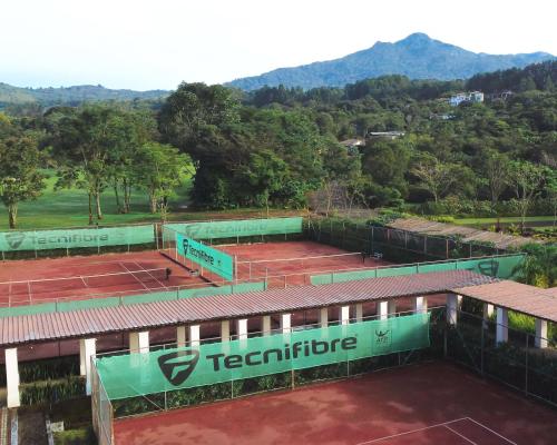 an aerial view of two tennis courts with mountains in the background at Lucero Golf and Country Club Tree Houses in Boquete