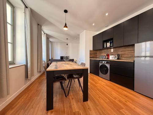 Il comprend une cuisine avec une table en bois et un réfrigérateur. dans l'établissement L'Ébène - Wifi - Proche des Halles et du centre ville, à Narbonne