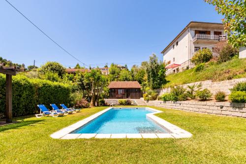 una piscina in un cortile con sedie e una casa di Bungalow Chalé da Caniçada a Rio Caldo