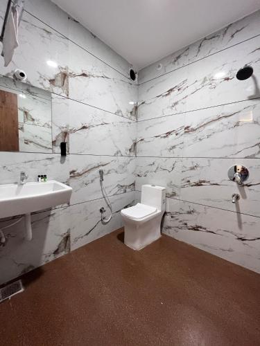 a bathroom with a toilet and a sink at Basotel Hotel Indore Vijaynagar in Indore