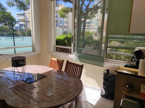 - une cuisine avec une table en bois et 2 fenêtres dans l'établissement T2 Plage la corniche, les Tennis de castelmare à Sète appartement classé 3 etoiles, à Sète