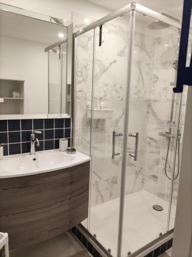 une salle de bain avec douche et lavabo dans l'établissement T2 Plage la corniche, les Tennis de castelmare à Sète appartement classé 3 etoiles, à Sète