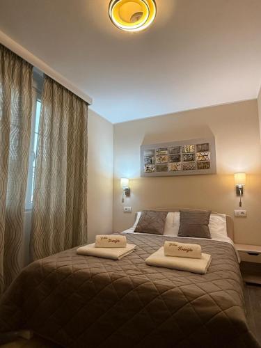 a bedroom with a bed with two towels on it at Vila Gracija in Arandelovac