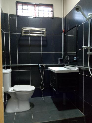 a bathroom with a toilet and a sink at KASMA HOMEsTELs in Kampong Permaisuri