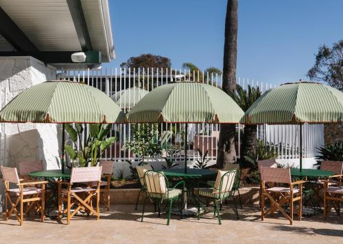a group of tables and chairs under umbrellas at Le Petit Pali Laguna Beach in Laguna Beach