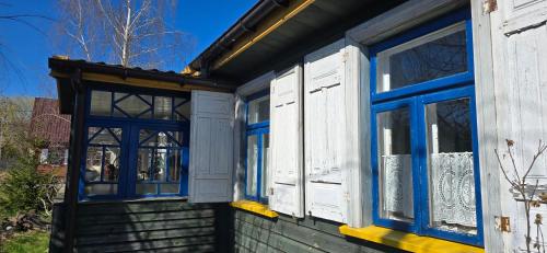 a house with blue and white windows on it at The Nest Koryciski Agroturystyka in Korycisk