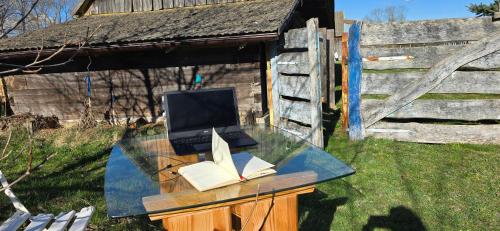 a glass desk with a laptop and books on it at The Nest Koryciski Agroturystyka in Korycisk