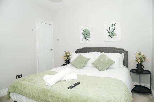 a bedroom with a bed with a remote control on it at Luxury 3-Bedroom Home , with Free parking in Dartford