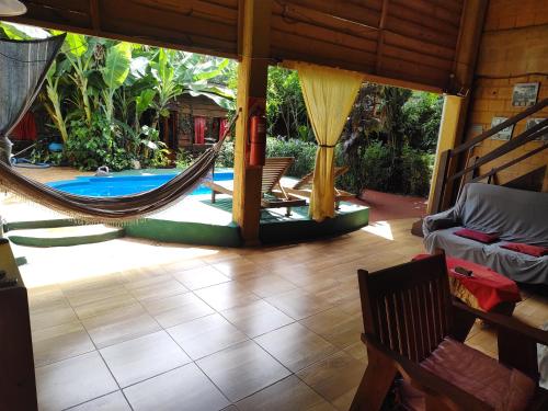 Una habitación con hamaca y piscina. en Nomads Hostel, en Puerto Iguazú