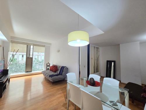 a living room with a glass table and white chairs at Heart of the City Great Apartment with Pool&Gym in Mexico City