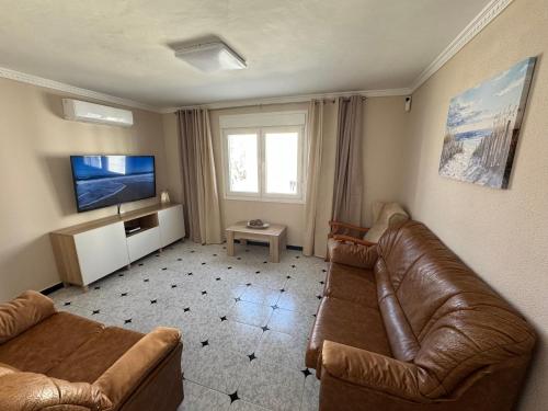 ein Wohnzimmer mit Couch und Flachbildfernseher in der Unterkunft Sol Atlántika Barbate in Barbate