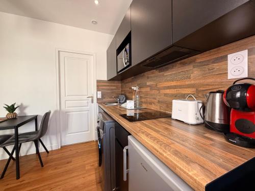 - une cuisine avec un comptoir en bois et une table dans l'établissement Le Saint Just T2 proche des Halles Wifi, à Narbonne