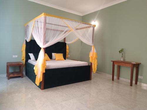 a bedroom with a bed with a canopy at B&B G&H house Zanzibar in Pingwe